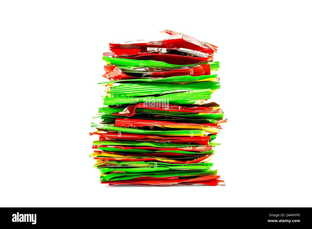 Pila di rosso, giallo e verde in plastica Lamina di confezioni di merendine. Cibo malsano, concetto di riciclaggio. Foto Stock