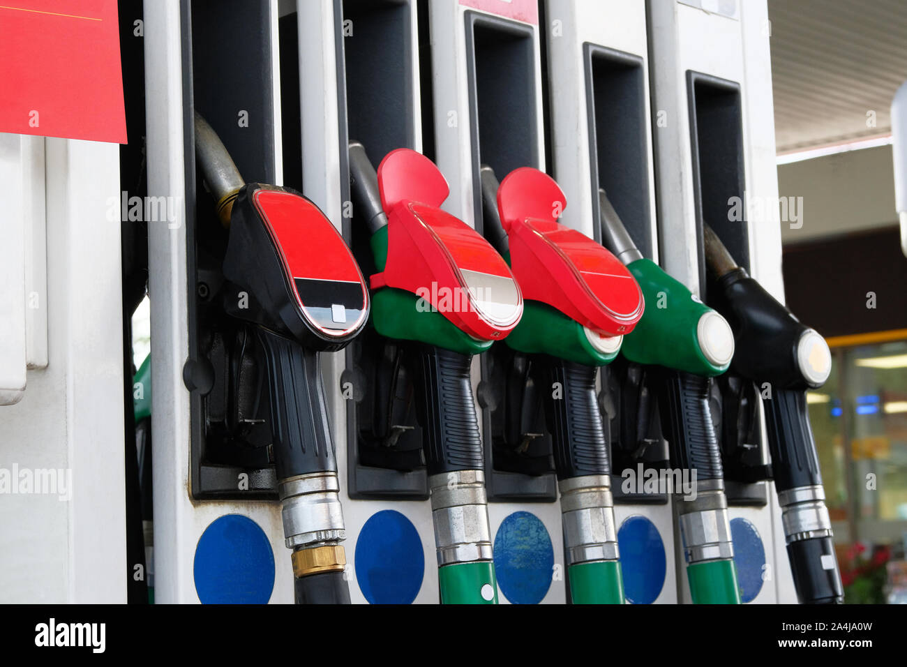 La benzina e olio prodotti concetto. Rosso e nero pistole carburante sulla stazione di carburante. Pompando benzina alla pompa di benzina. Close up. Foto Stock