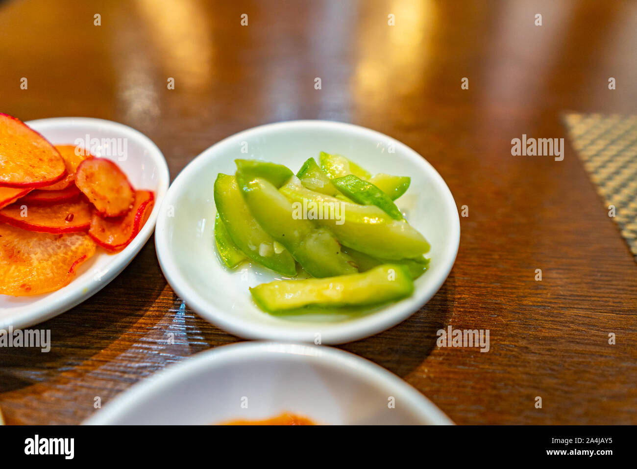 Primo piano di una succulenta piccante e saporito appena le fette di cetriolo coreana su una piastra bianca Foto Stock