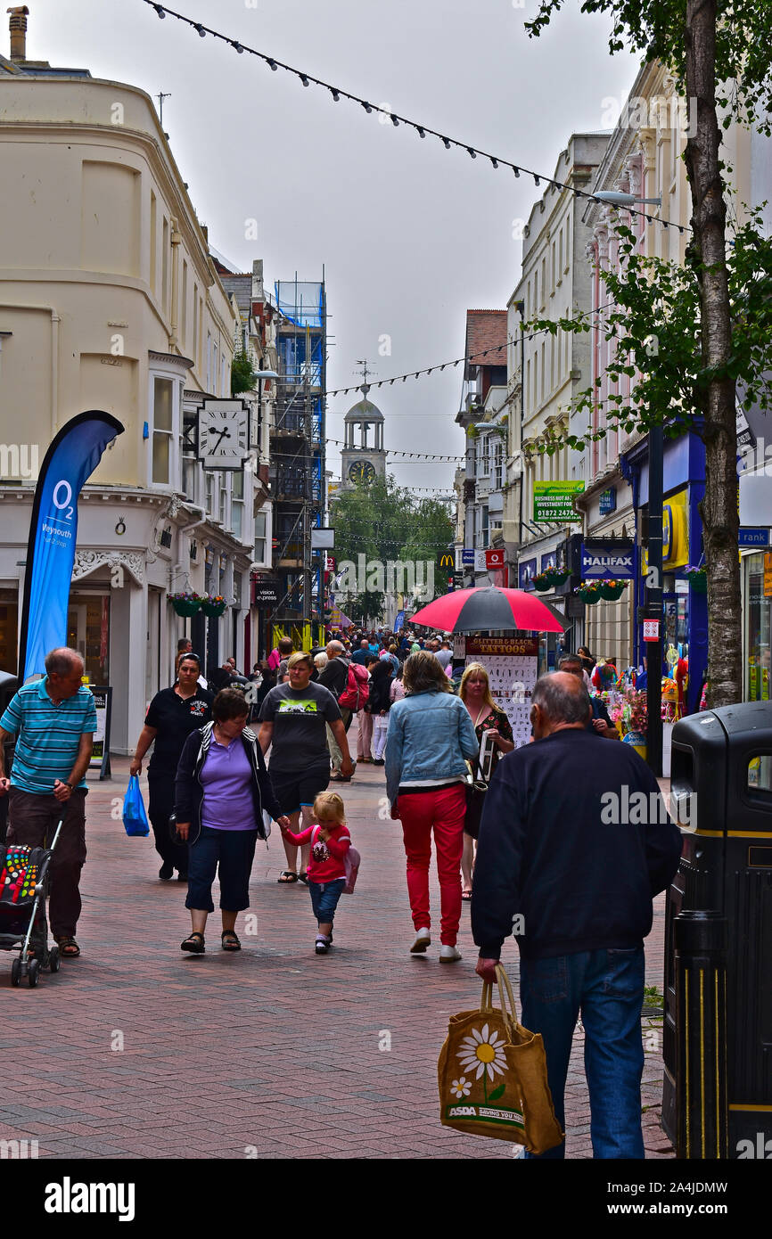 Una vista lungo St Mary Street a Weymouth Town Center. Vecchio montato a parete in stile Art Deco clock. Torre dell Orologio sopra la chiesa di Saint Mary. Foto Stock