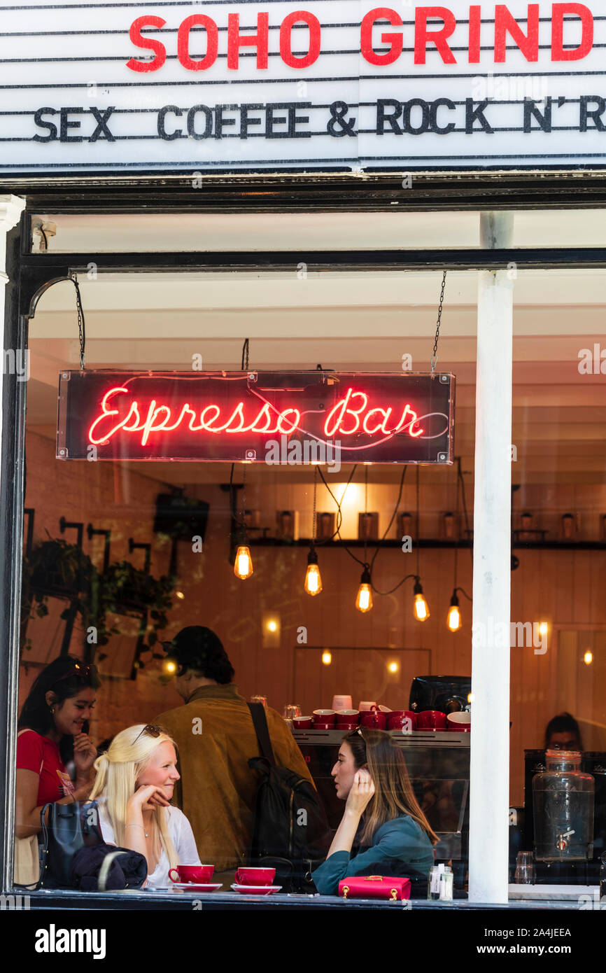 Due giovani donne di caffè all'interno del Soho smerigliare espresso bar di Soho, la zona centrale di Londra, Inghilterra, Regno Unito. Foto Stock