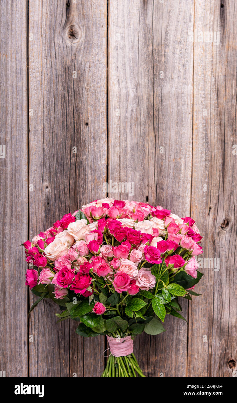 Un mazzo di rose su uno sfondo di legno. Foto Stock