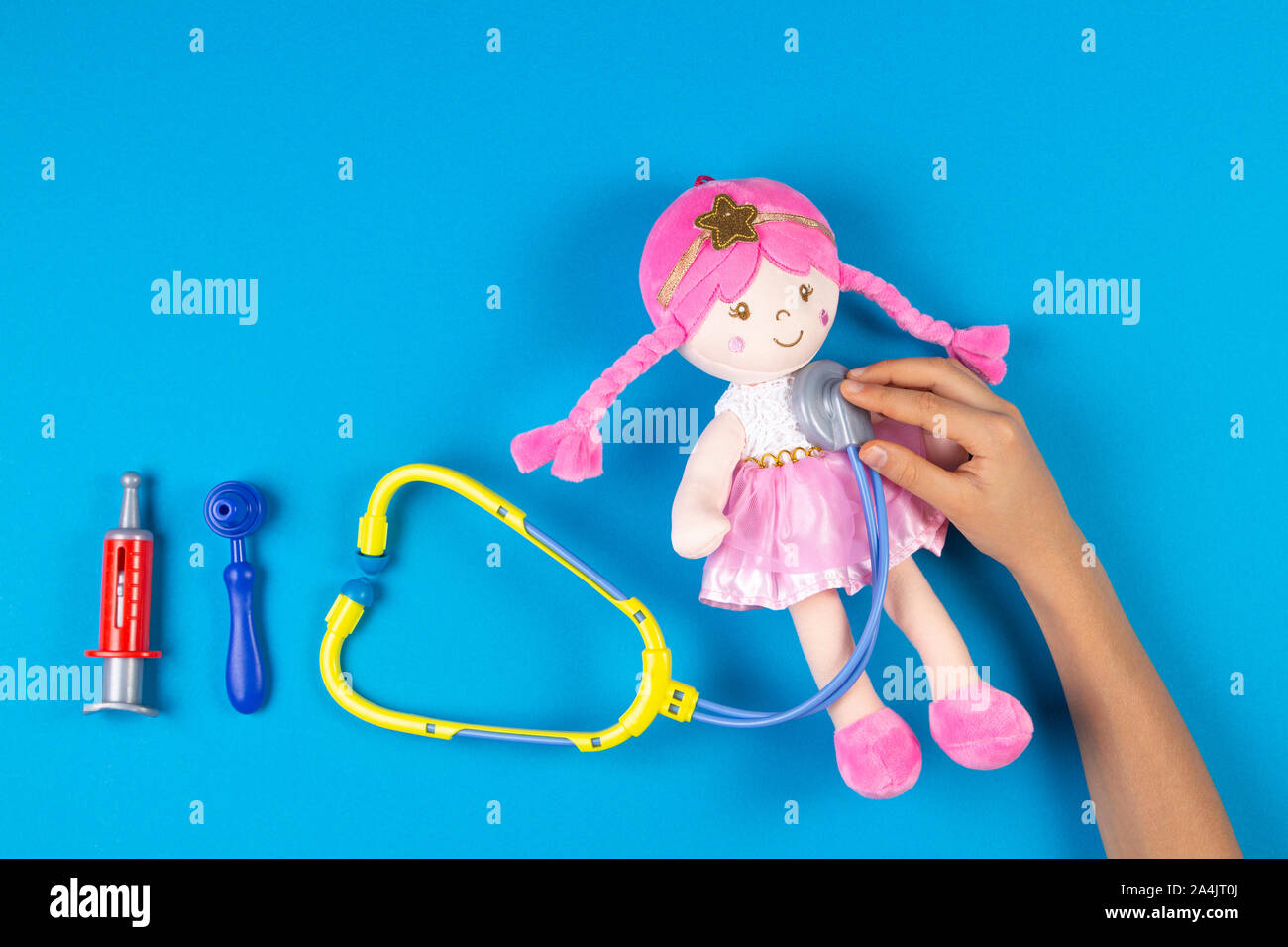 Kid mani con stetoscopio giocattolo, poco bambola giocattolo e