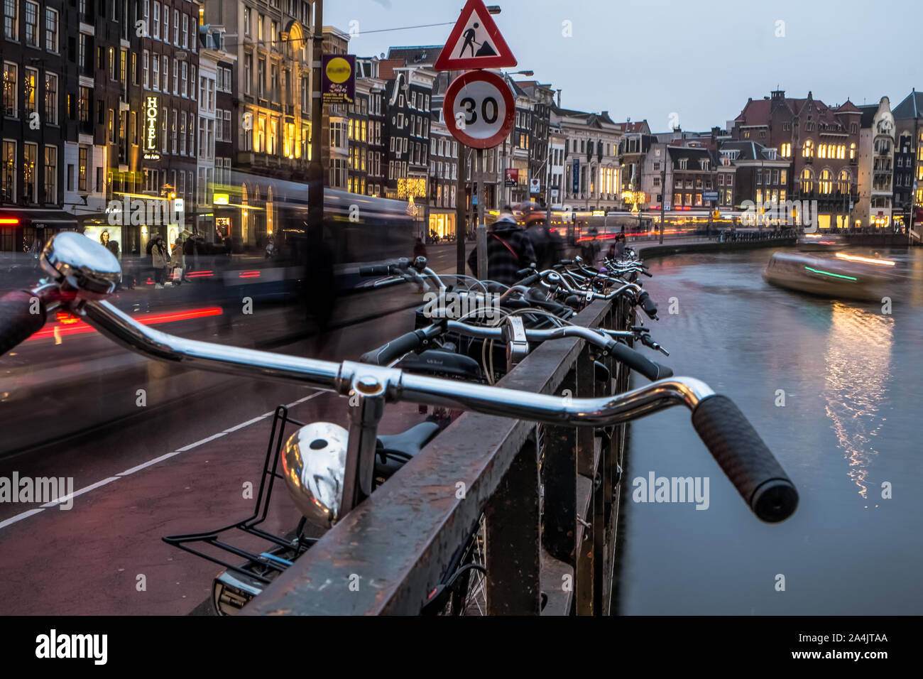 Illuminati canali di Amsterdam atmosfera,imbarcazioni turistiche, architettura e biciclette Foto Stock