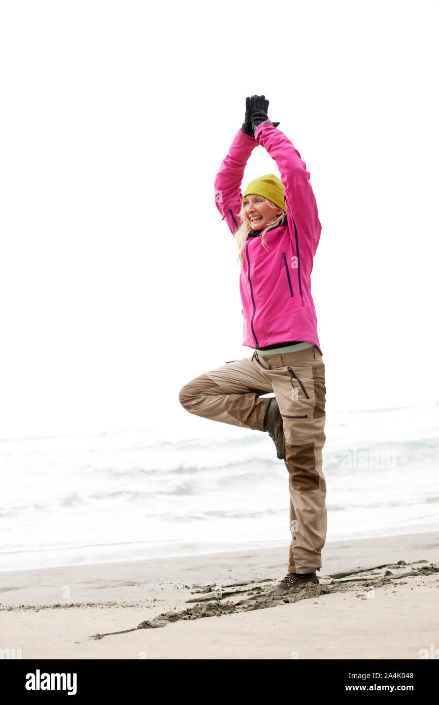 Donna fare yoga in Kvalvika, Lofoten Foto Stock