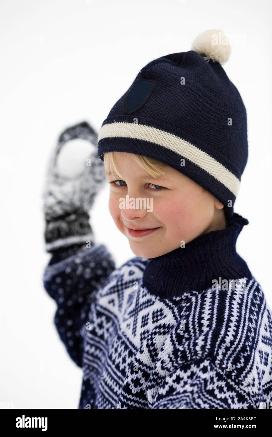 Naughty guy lanciare una palla di neve. Tipici norvegesi maglione. Foto Stock