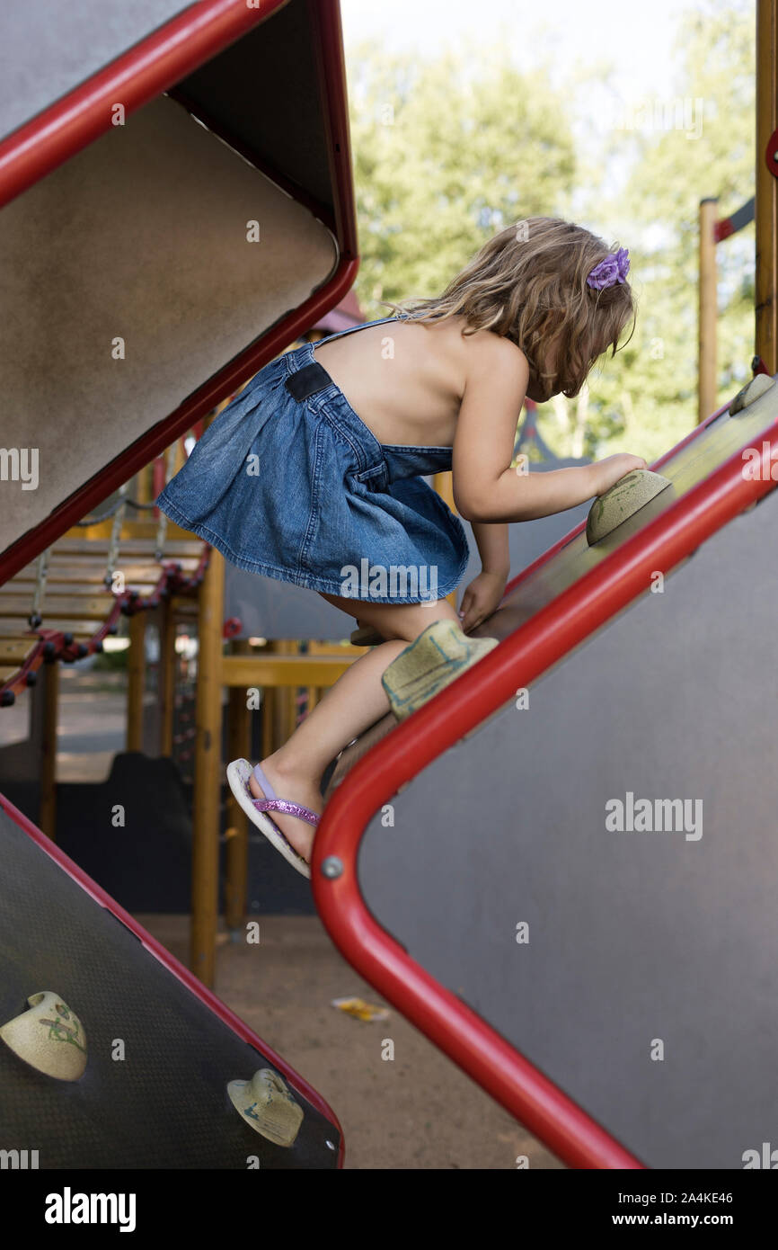 Bambina gioca a un parco giochi per bambini Foto Stock