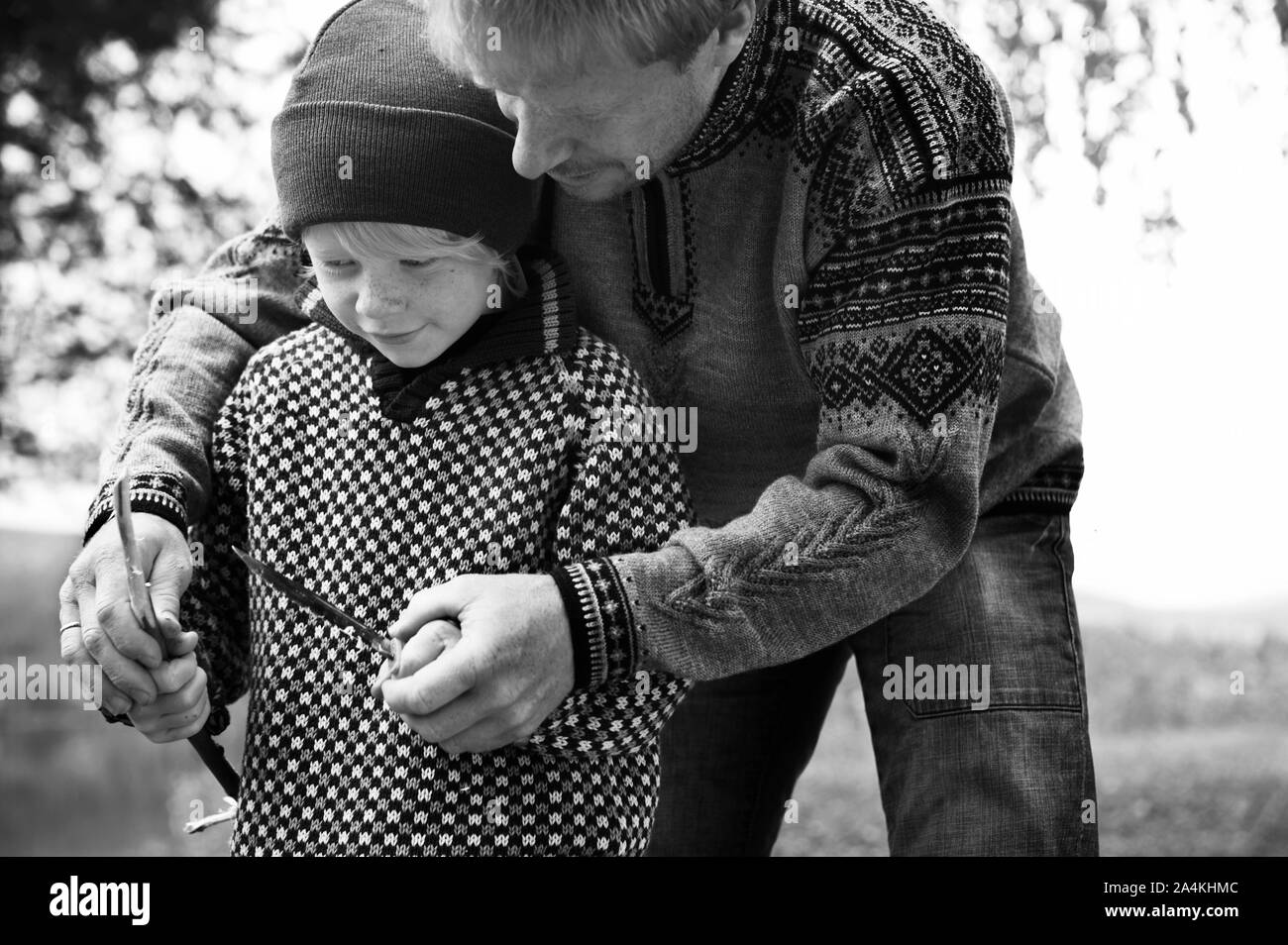 Padre whittling con figlio Foto Stock