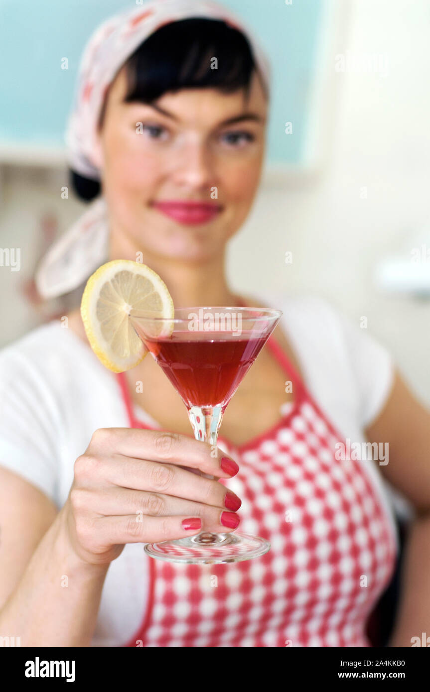 Donna che indossa il grembiule azienda bicchiere da cocktail Foto Stock