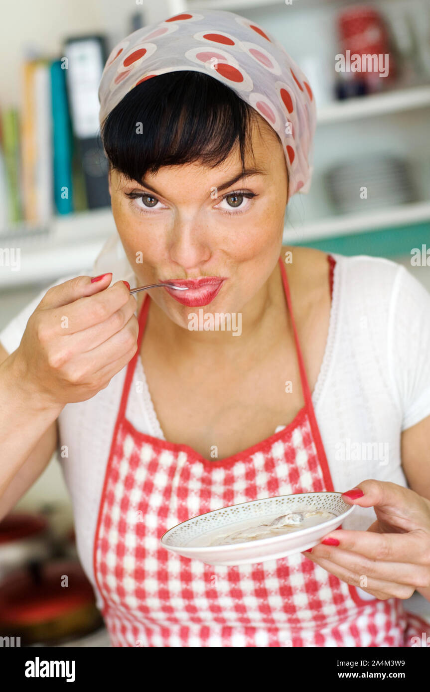 La casalinga con grembiule cucina degustazione Foto Stock
