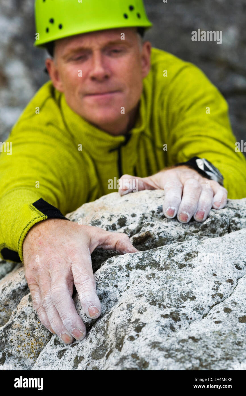 L'uomo salendo una roccia Foto Stock