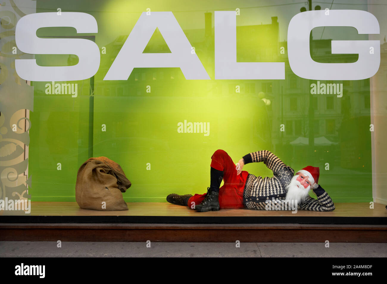 Santa Claus in appoggio in un negozio di vendita finestra Foto Stock