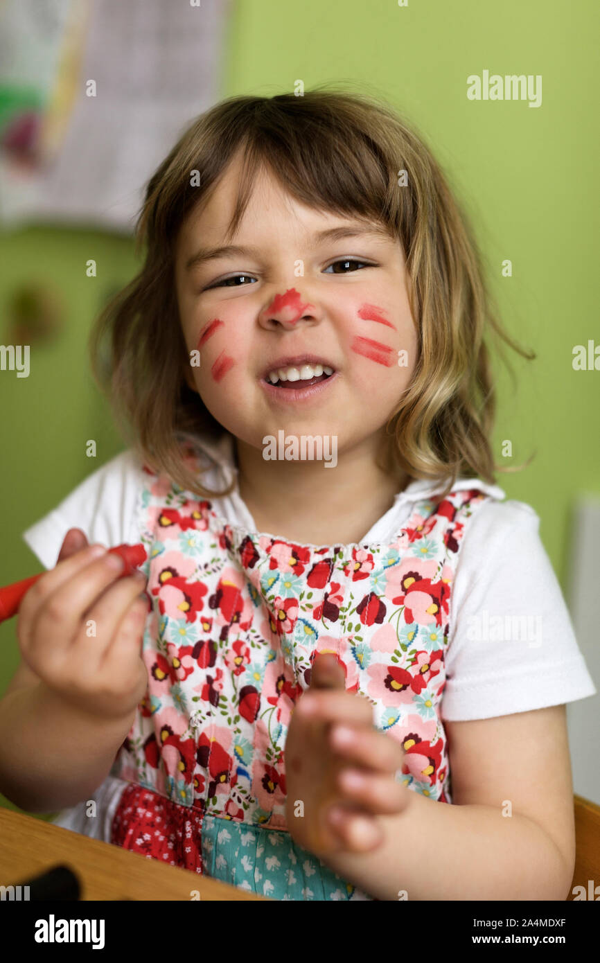 Graziosa Bambina con vernice colorata sul suo viso Foto Stock