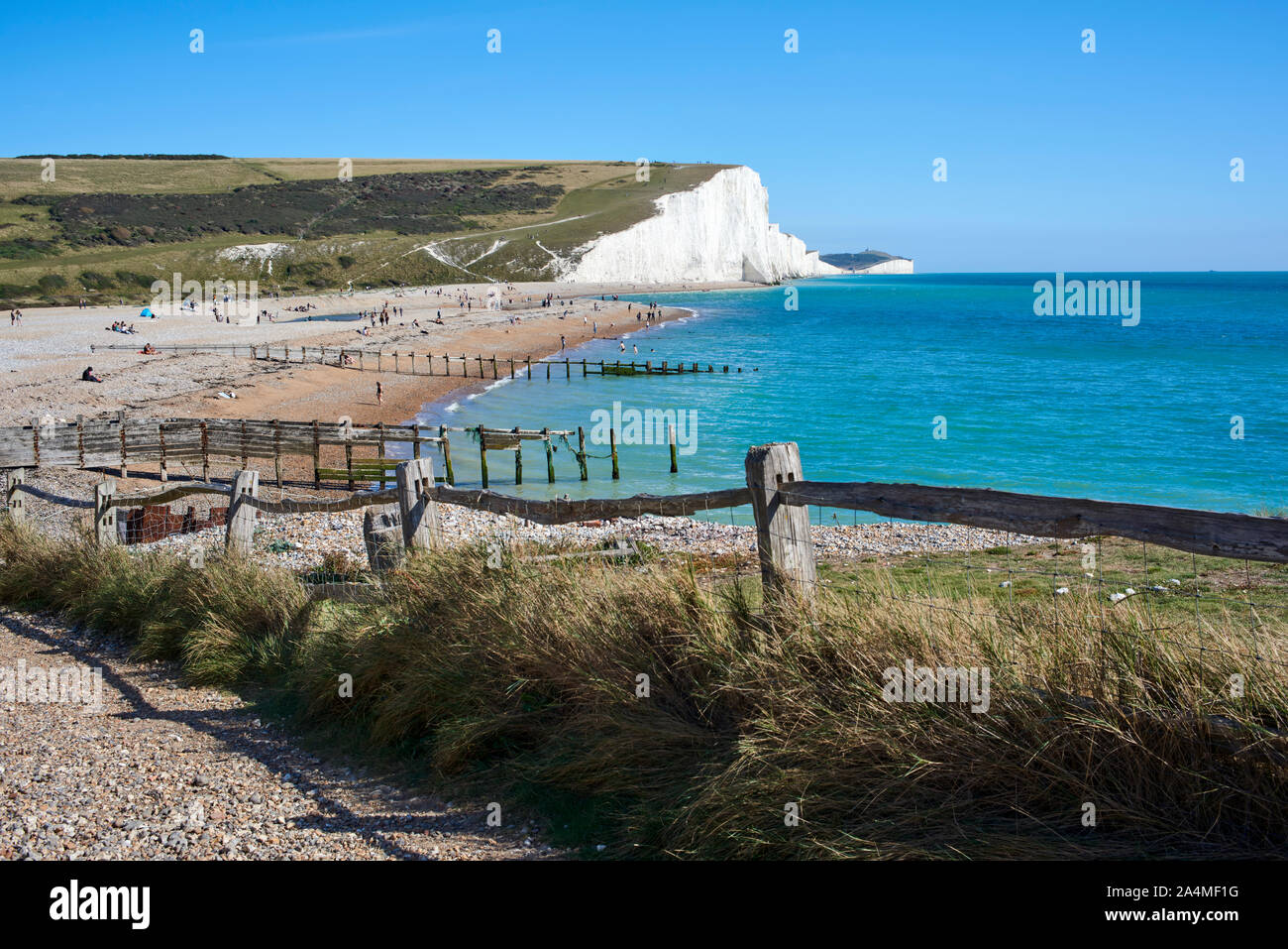Percorso lungo la riva del mare e spiaggia a Cuckmere Haven sulla costa sud, East Sussex, Regno Unito, con le sette sorelle chalk cliffs in background Foto Stock