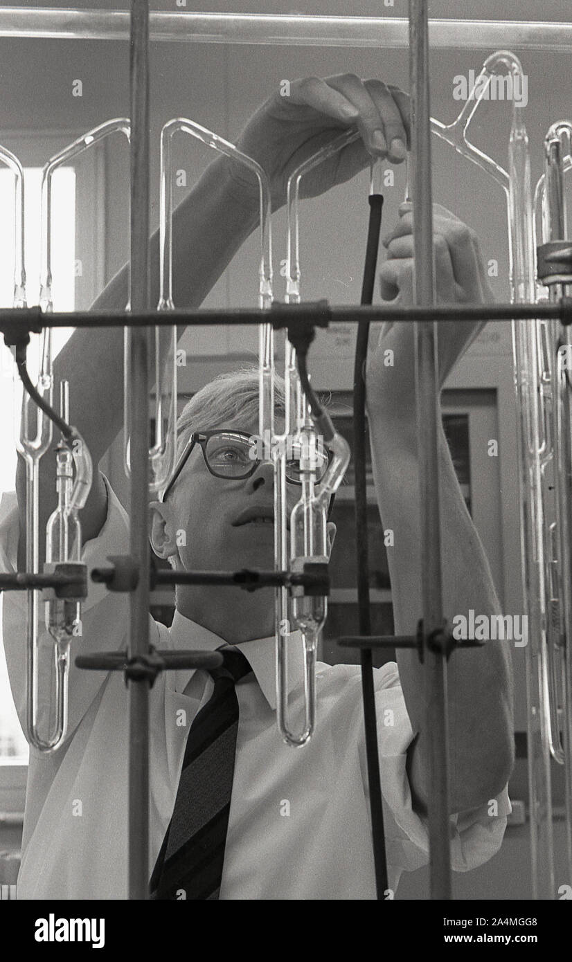 1960, storico, uno studente maschio che lavora con provette di vetro in un laboratorio chimico presso la University of Southern California (USC), USA. Foto Stock