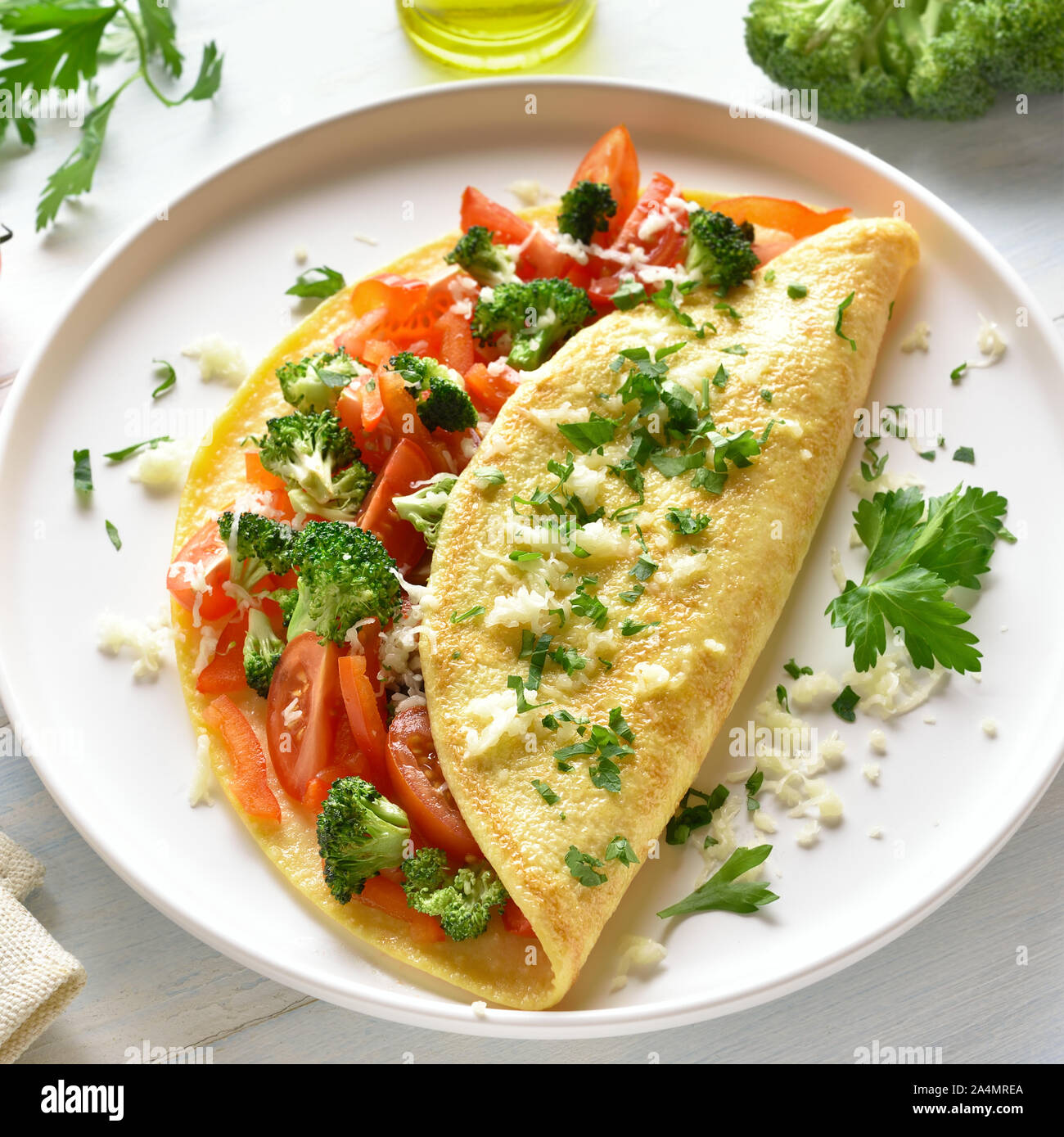 Omelette ripiene con pomodori, peperone rosso e broccoli luce sul tavolo di legno. Alimentazione sana alimenti per la colazione. Gustoso cibo di mattina. Foto Stock