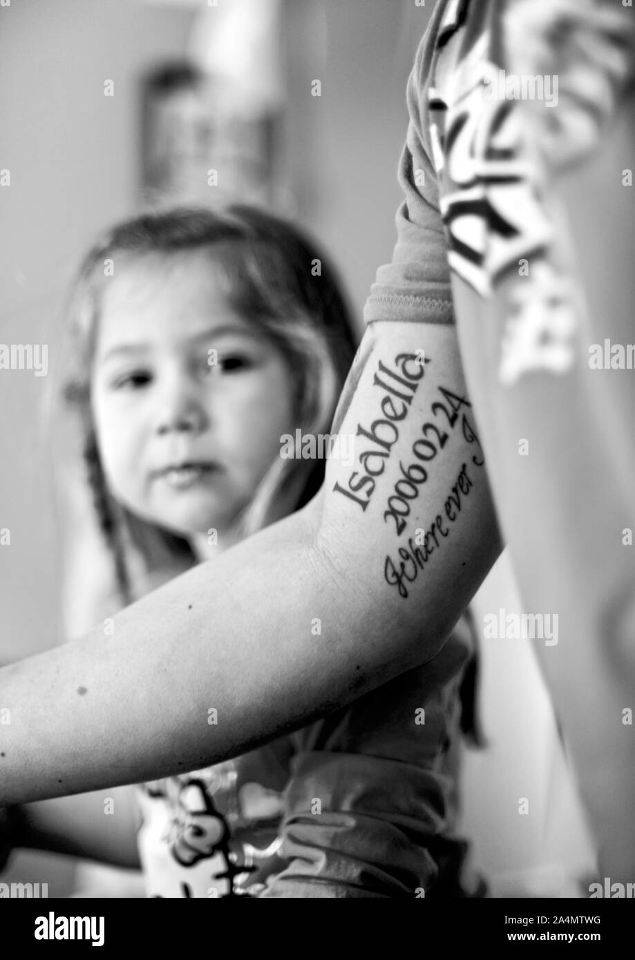 Tatuaggio sul braccio, ragazza sullo sfondo Foto Stock