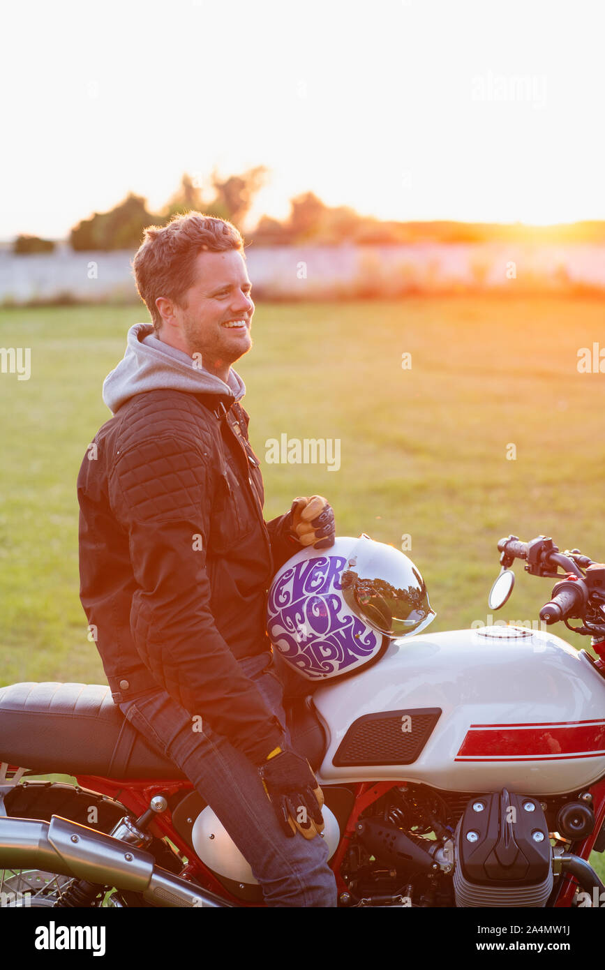 Uomo sorridente in moto Foto Stock
