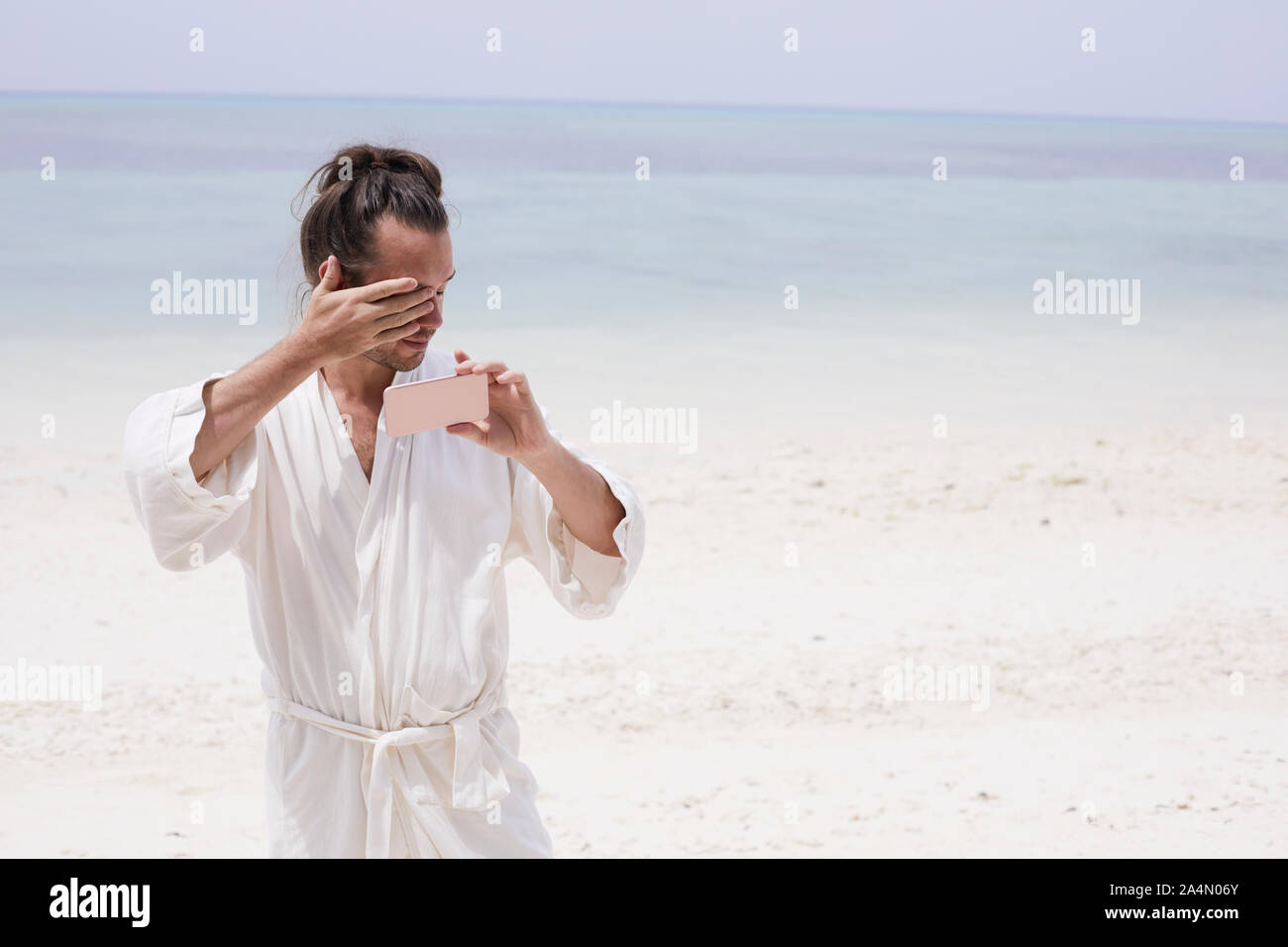 Uomo che indossa vestaglia sulla spiaggia Foto Stock