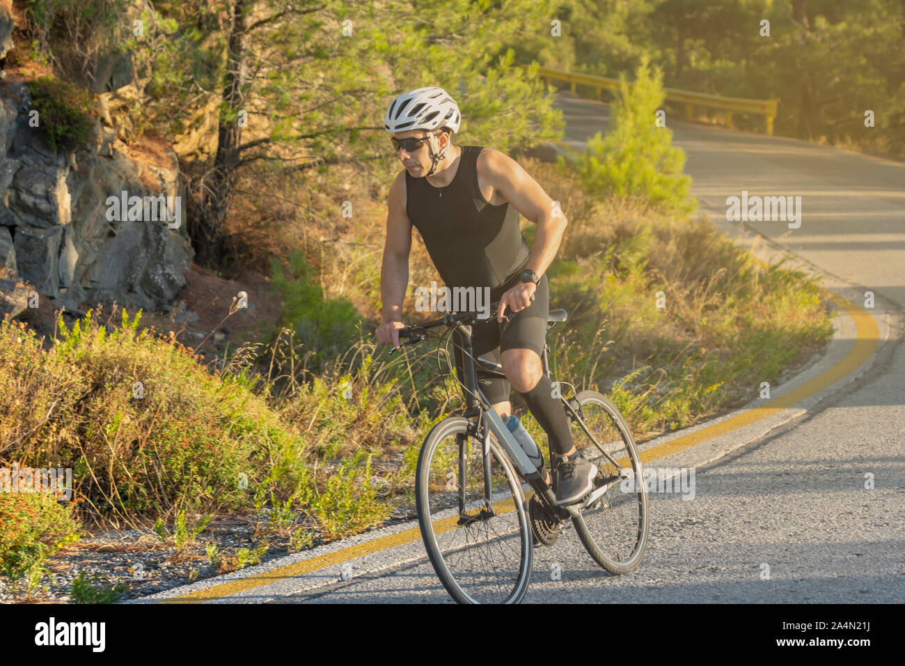 Biker maschio escursioni in bicicletta su una strada di montagna - Sport e stile di vita attivo concept Foto Stock