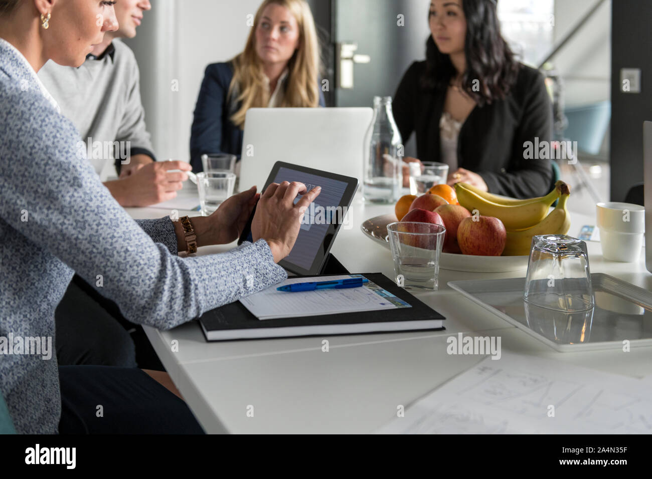 Donna con tavoletta digitale a business meeting Foto Stock