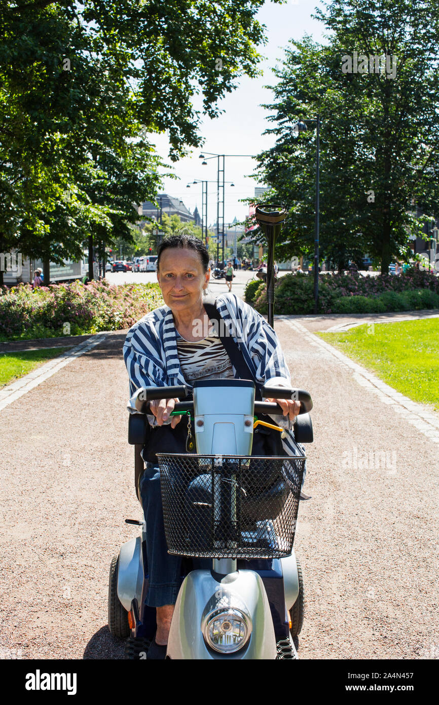 Donna sulla mobilità scooter Foto Stock