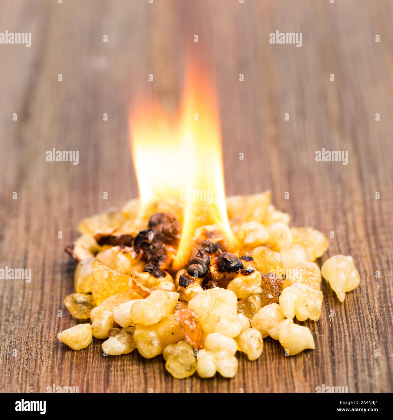 Incenso che brucia con una fiamma su legno Foto Stock