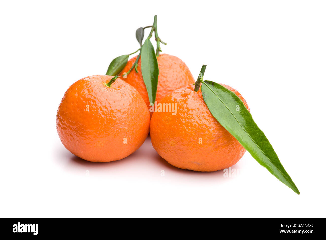 3 tangerini con roba verde Foto Stock