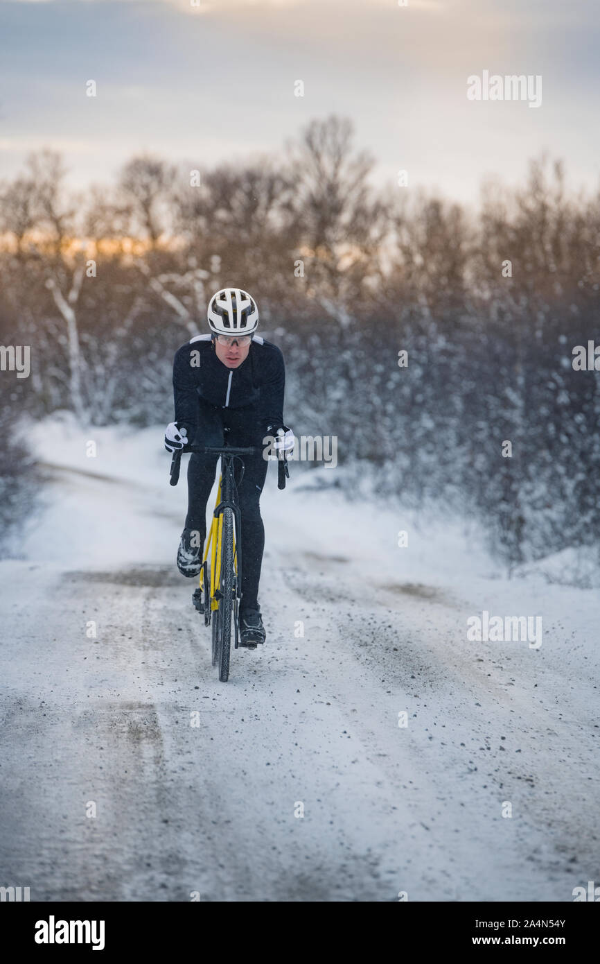 Uomo in bicicletta in inverno Foto Stock
