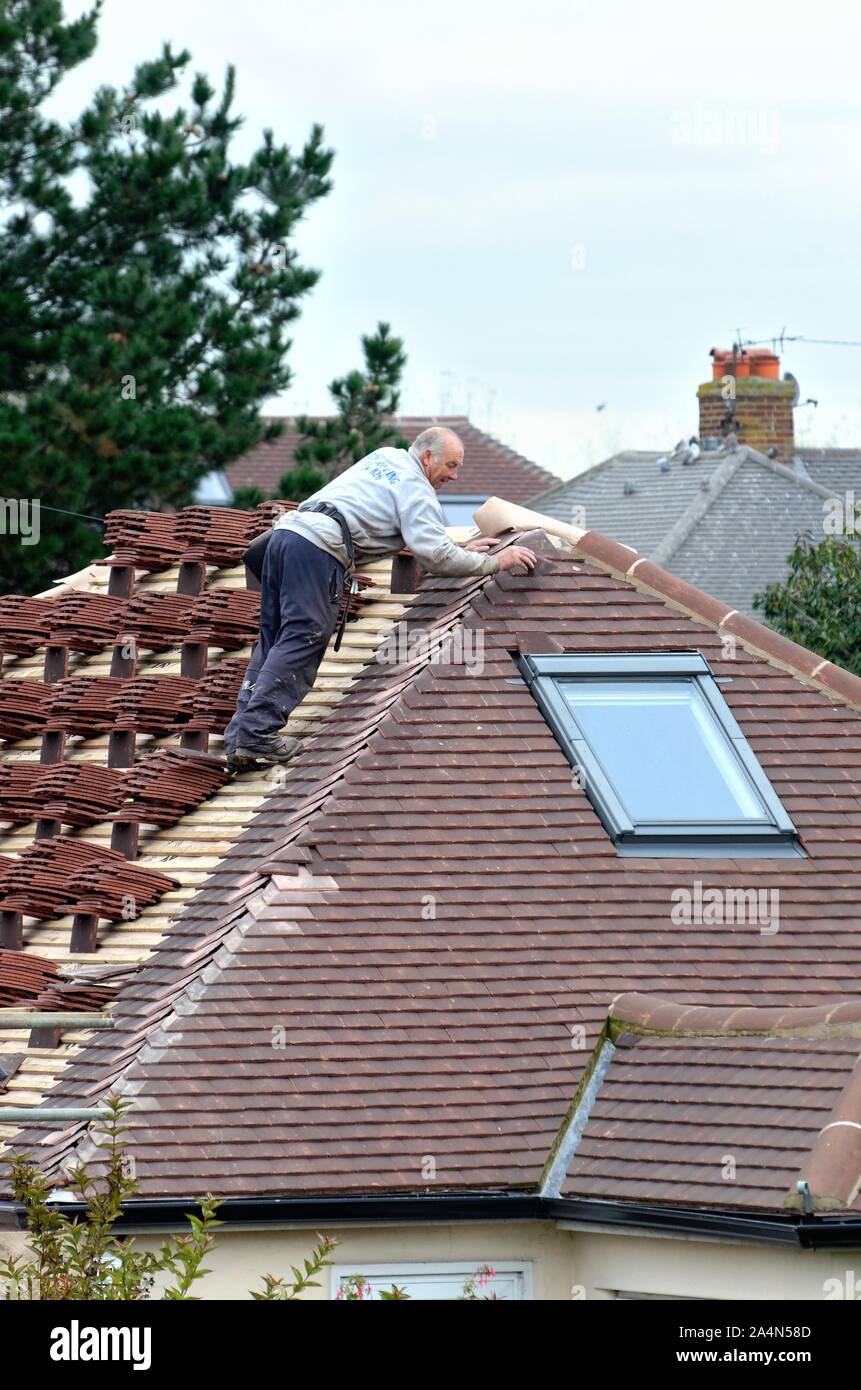 Tassellamento Builder un tetto su una zona residenziale bungalow in Shepperton Surrey in Inghilterra REGNO UNITO Foto Stock