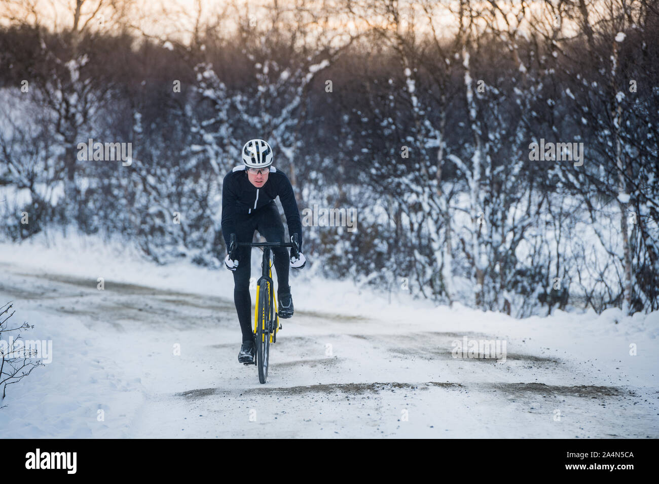 Uomo in bicicletta in inverno Foto Stock