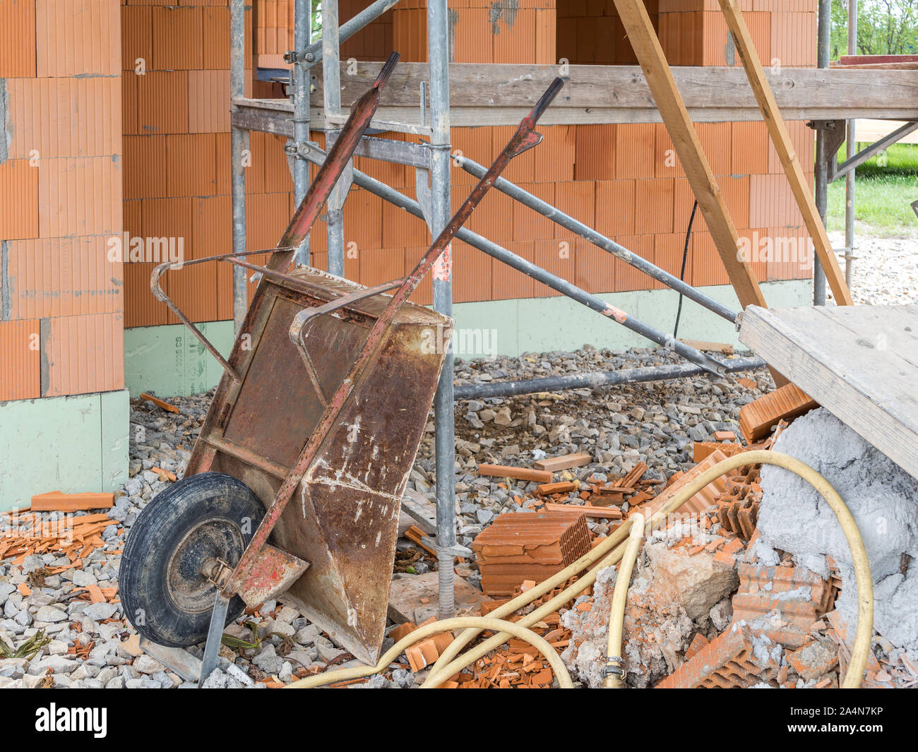 Vecchio arrugginito carriola mentre la costruzione di una casa Foto Stock