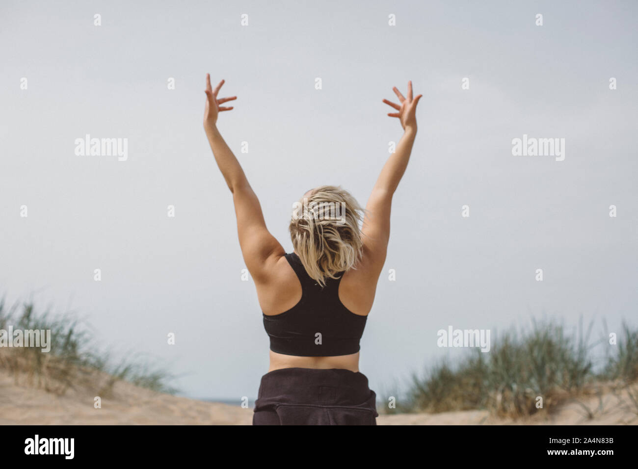 Donna con braccia alzate Foto Stock