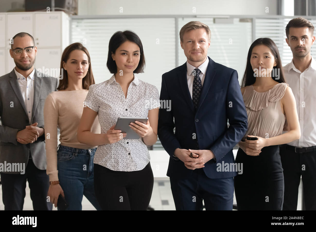 Ritratto di successo diversi team di dipendenti in piedi in ufficio Foto Stock