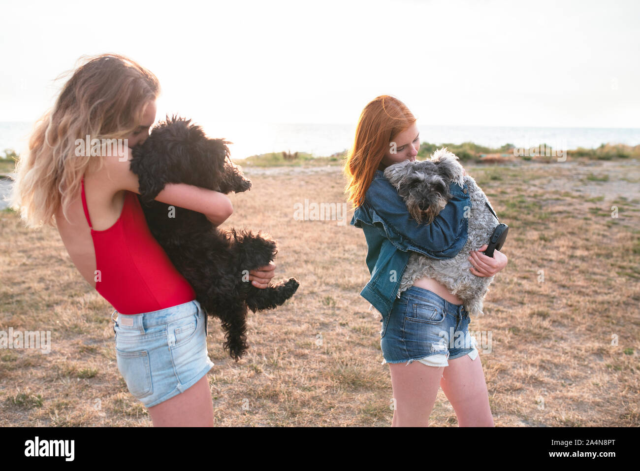Le ragazze adolescenti che abbraccia i loro cani Foto Stock