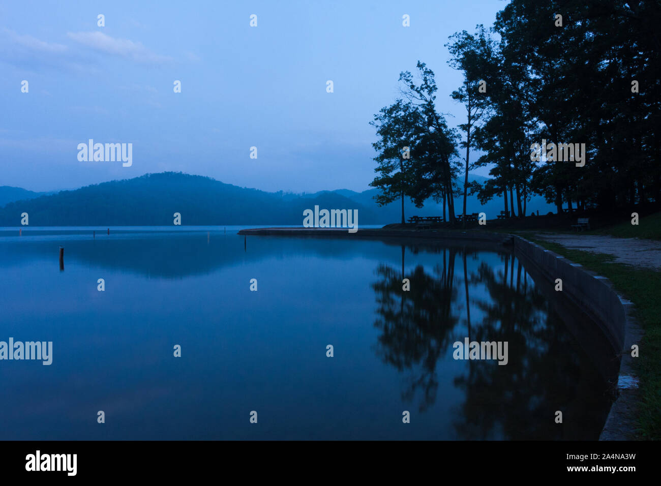 Un moody blue serata presso un lago di montagna parco. Foto Stock