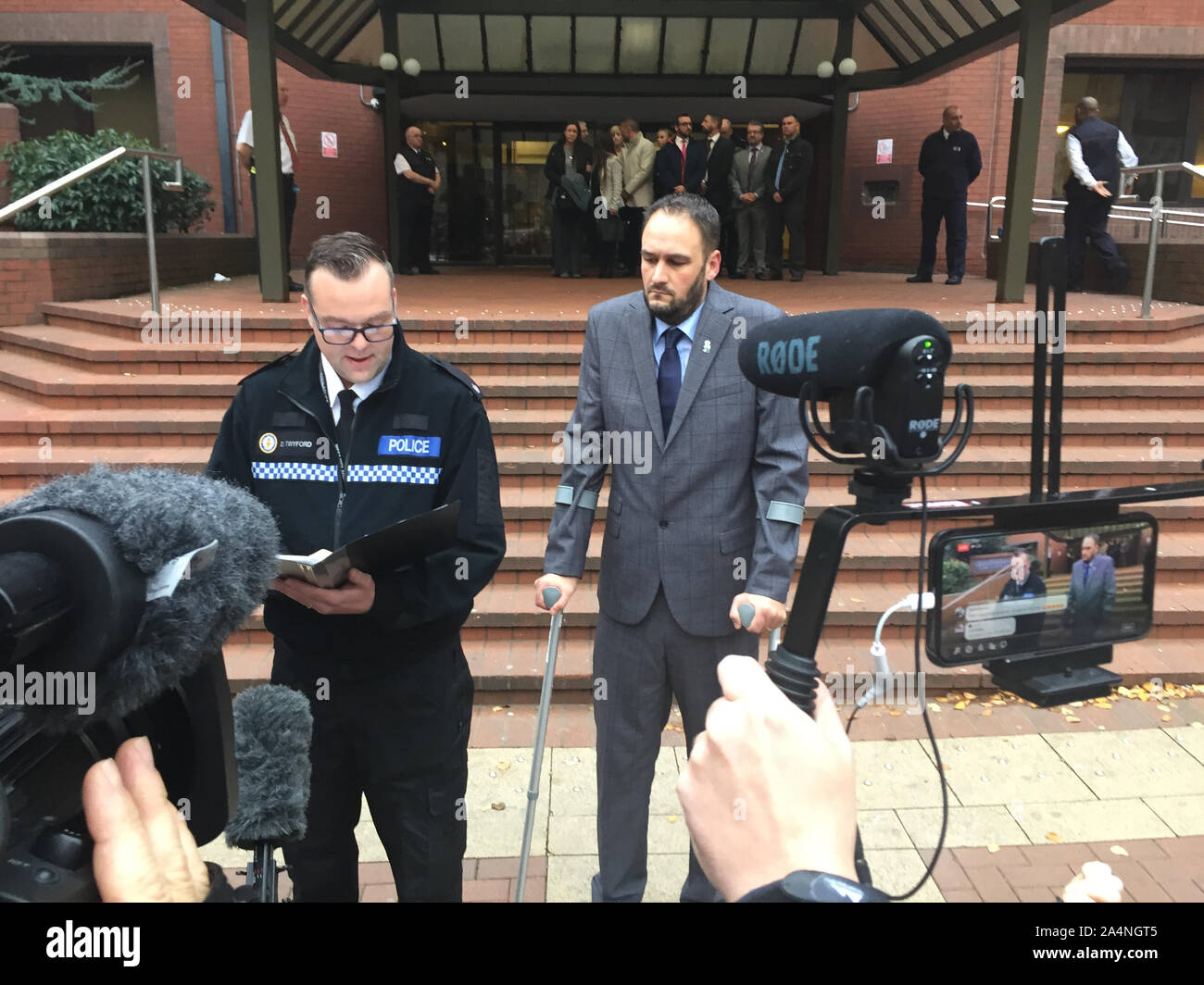 Supt Dave Twyford, capo della polizia stradale di West Midlands Polizia, recita una dichiarazione al di fuori Birmingham Crown Court al fianco di Pc Gareth Phillips, ladro di auto Mubashar Hussain è stato imprigionato per un periodo di dodici anni per il funzionamento su PC Phillips in un dirottato auto della polizia. Foto Stock