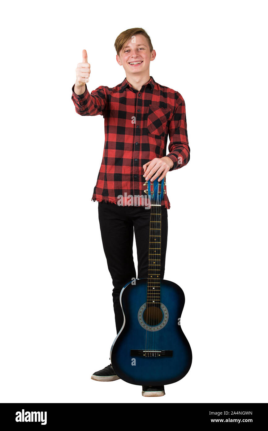 A piena lunghezza Ritratto di bello ragazzo adolescente in posa con il suo preferito blue chitarra acustica, mostrando il pollice fino gesto positivo, isolato sul retro bianco Foto Stock