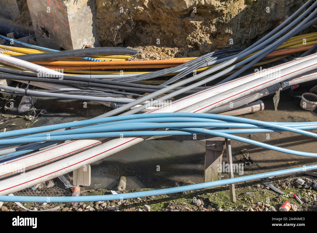 Diversi cavi, elettricità, telefono, Internet, giacciono aperto in un edificio pit, nuova installazione, Foto Stock