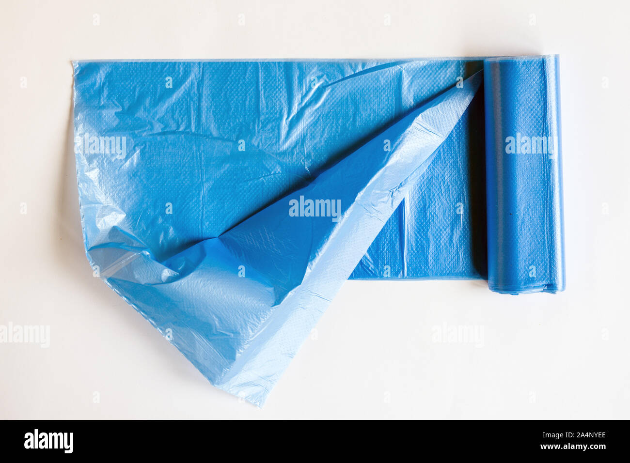 Rotolo di sacco dei rifiuti di plastica su sfondo bianco. Rifiuti borsa blu per il lavoro domestico. Foto Stock