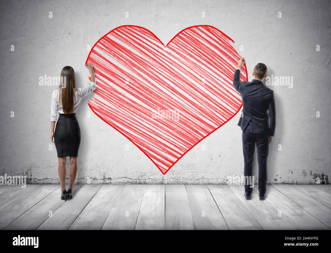 Imprenditore e imprenditrice disegno grande cuore rosso sulla parete di cemento Foto Stock