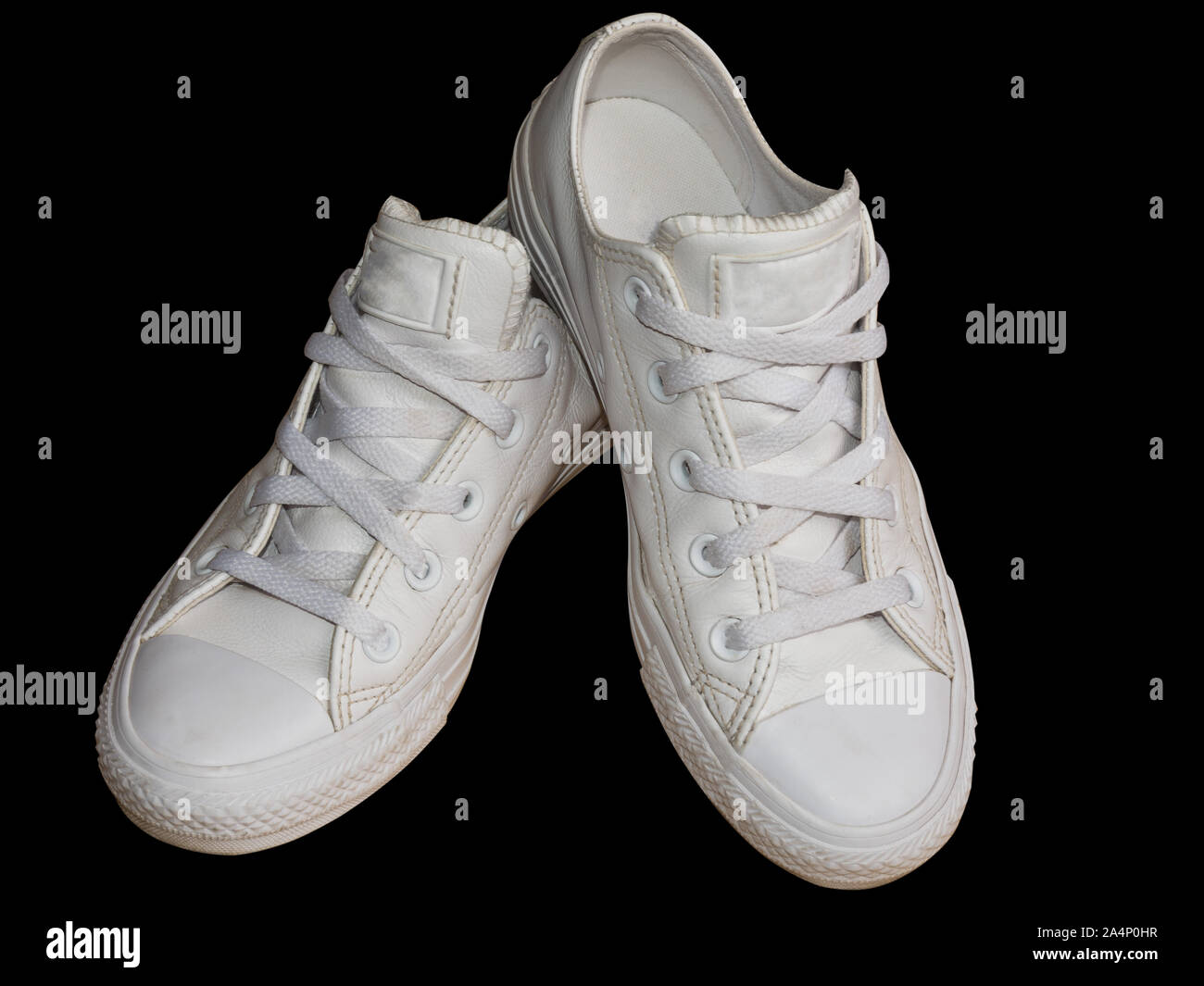Bianco alla moda in pelle femmina sneakers closeup isolati su sfondo nero. Stile donna calzature casual Foto Stock
