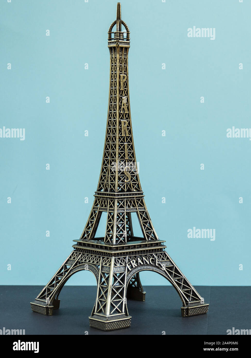 Toy torre eiffel sul pastello blu sullo sfondo. Parigi souvenir, simbolo della Francia. Foto Stock