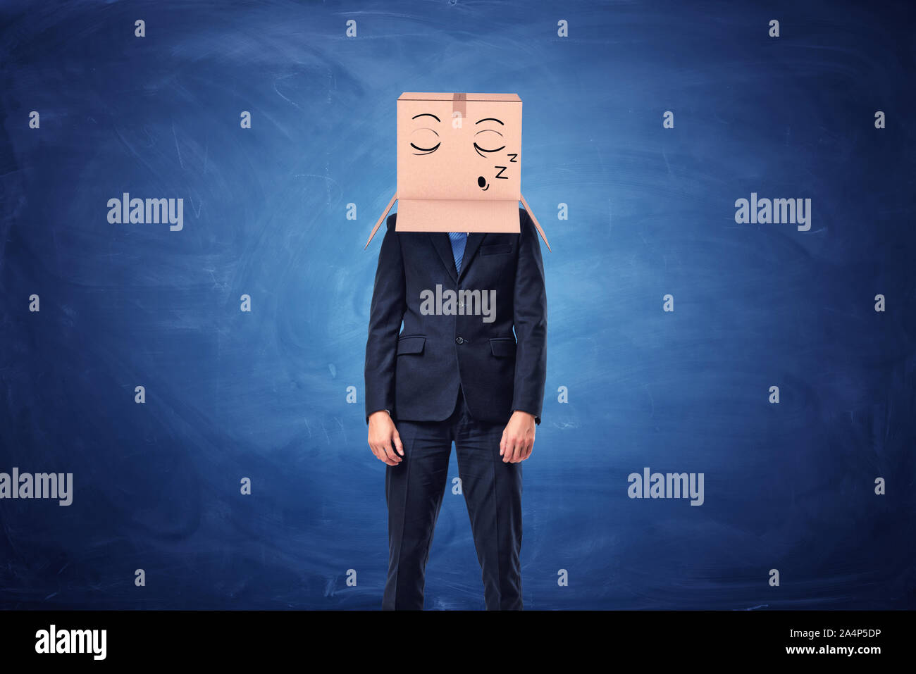 Imprenditore indossa una scatola di cartone in testa con il viso assonnato Foto Stock
