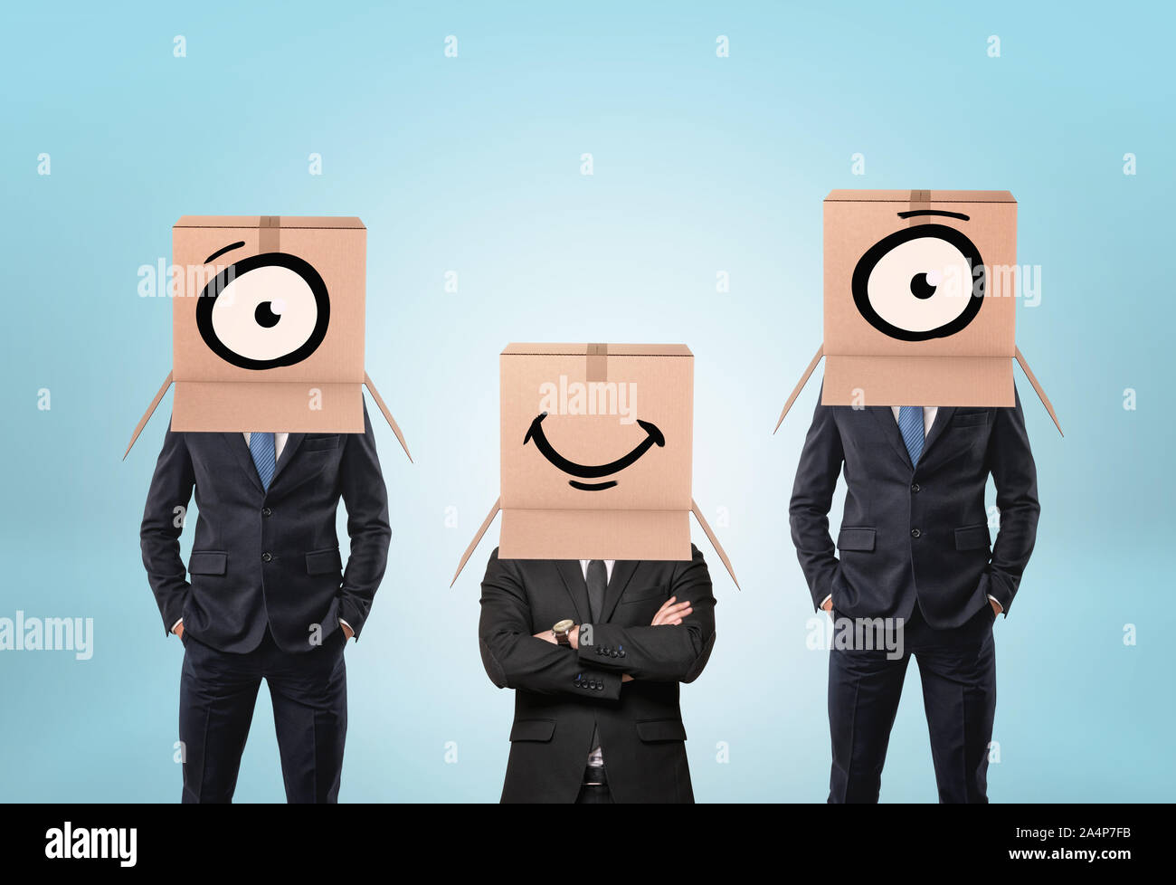 Tre uomini di affari che indossa i cartoni sulle loro teste con tratte della bocca e degli occhi Foto Stock