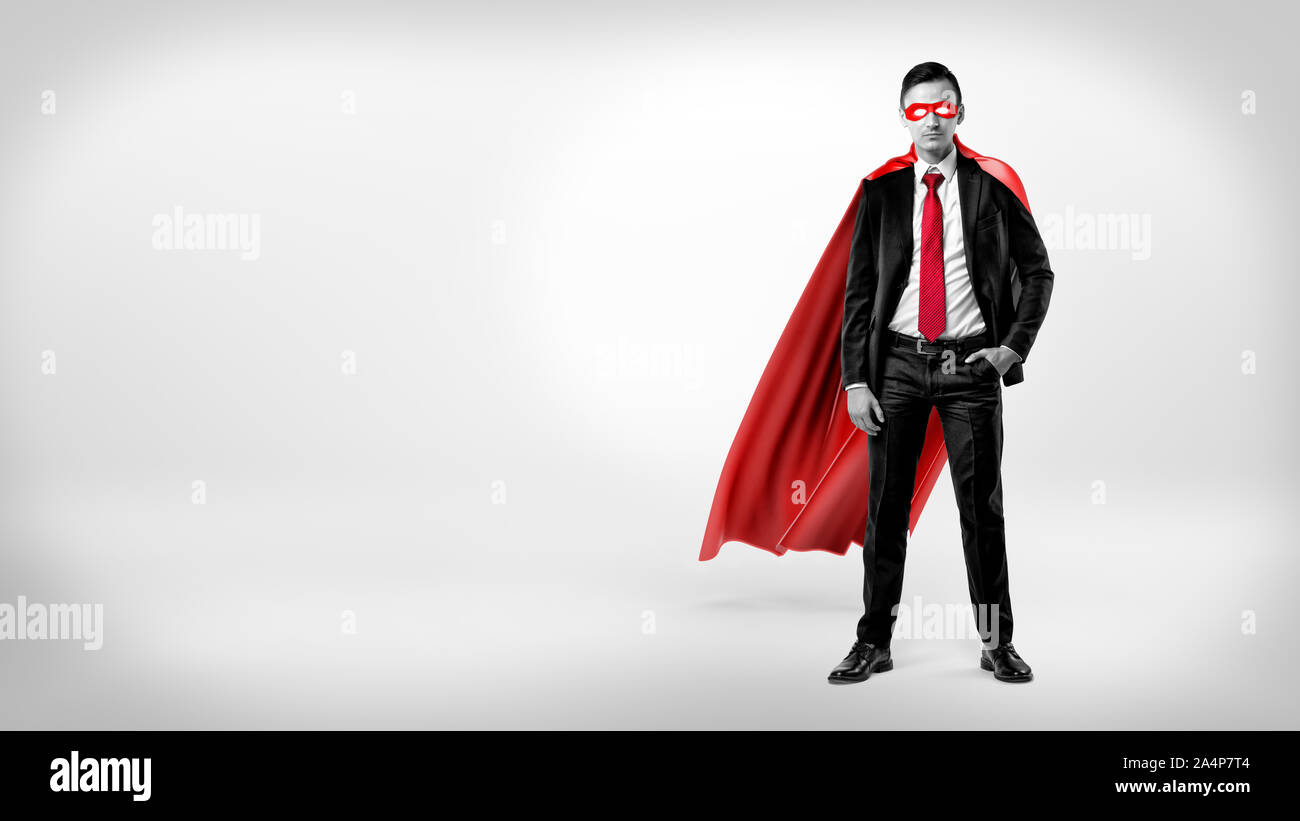 Un auto-imprenditore assicurato in un mantello rosso e una maschera in piedi con una mano in tasca su sfondo bianco. Foto Stock