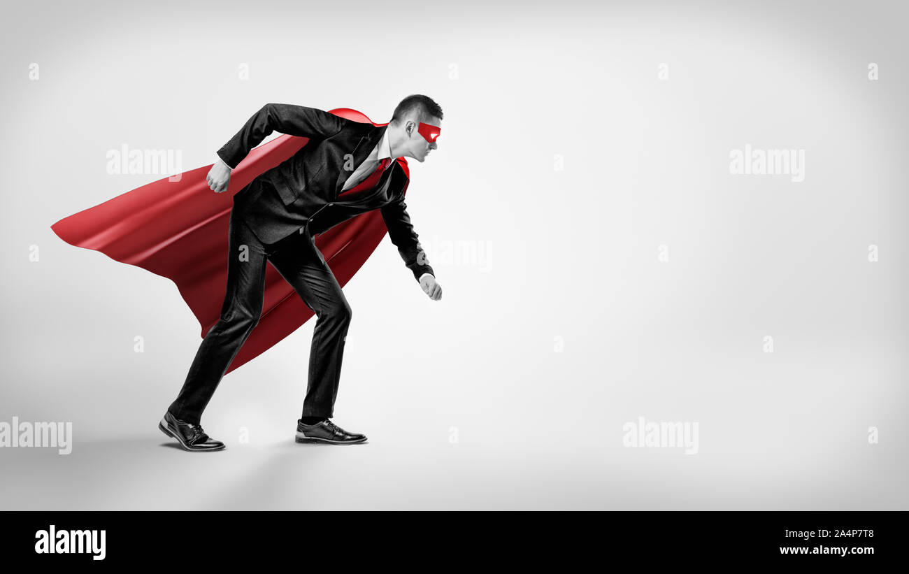 Un imprenditore in un supereroe red cape e una maschera in piedi nella linea di partenza posizione su sfondo grigio. Foto Stock