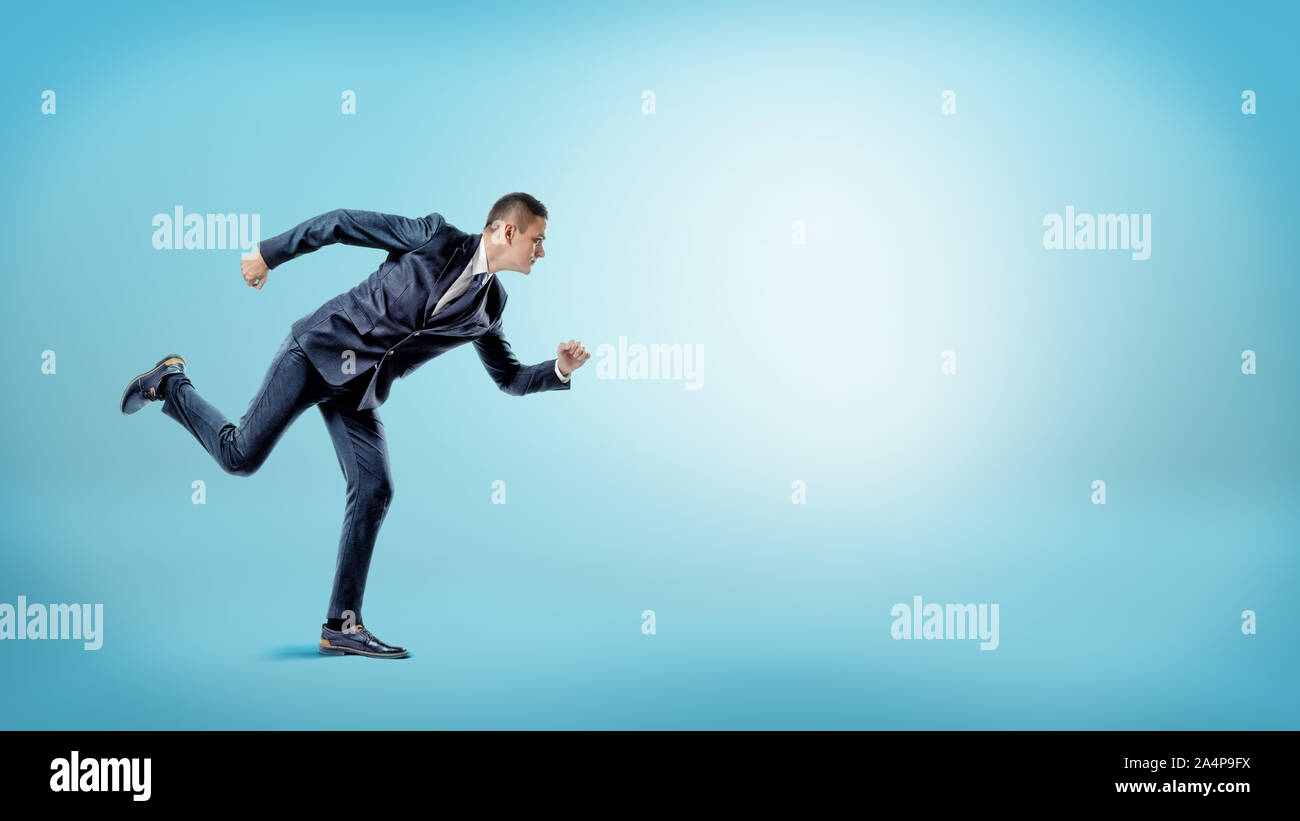 Un imprenditore in un runner posizione pronto per l'avvio su sfondo blu. Nuove opportunità di business. Foto Stock
