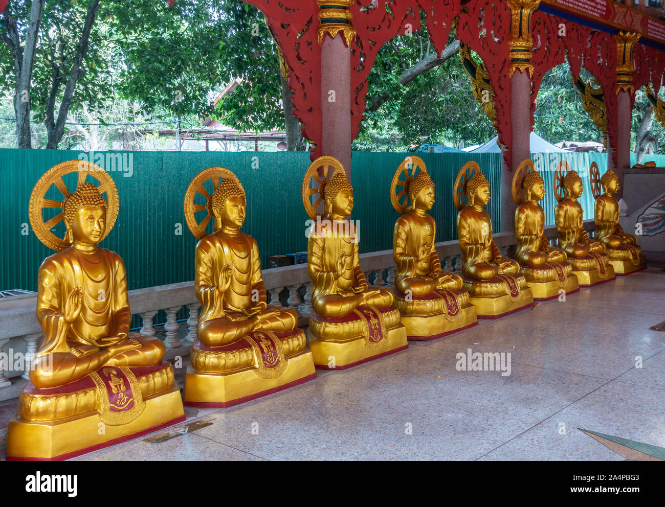 Bang Saen, Tailandia - 16 Marzo 2019: Wang Saensuk monastero buddista. Linea di Golden statue del Bodhisattva sul lato di apertura principale sala da preghiera. Green f Foto Stock