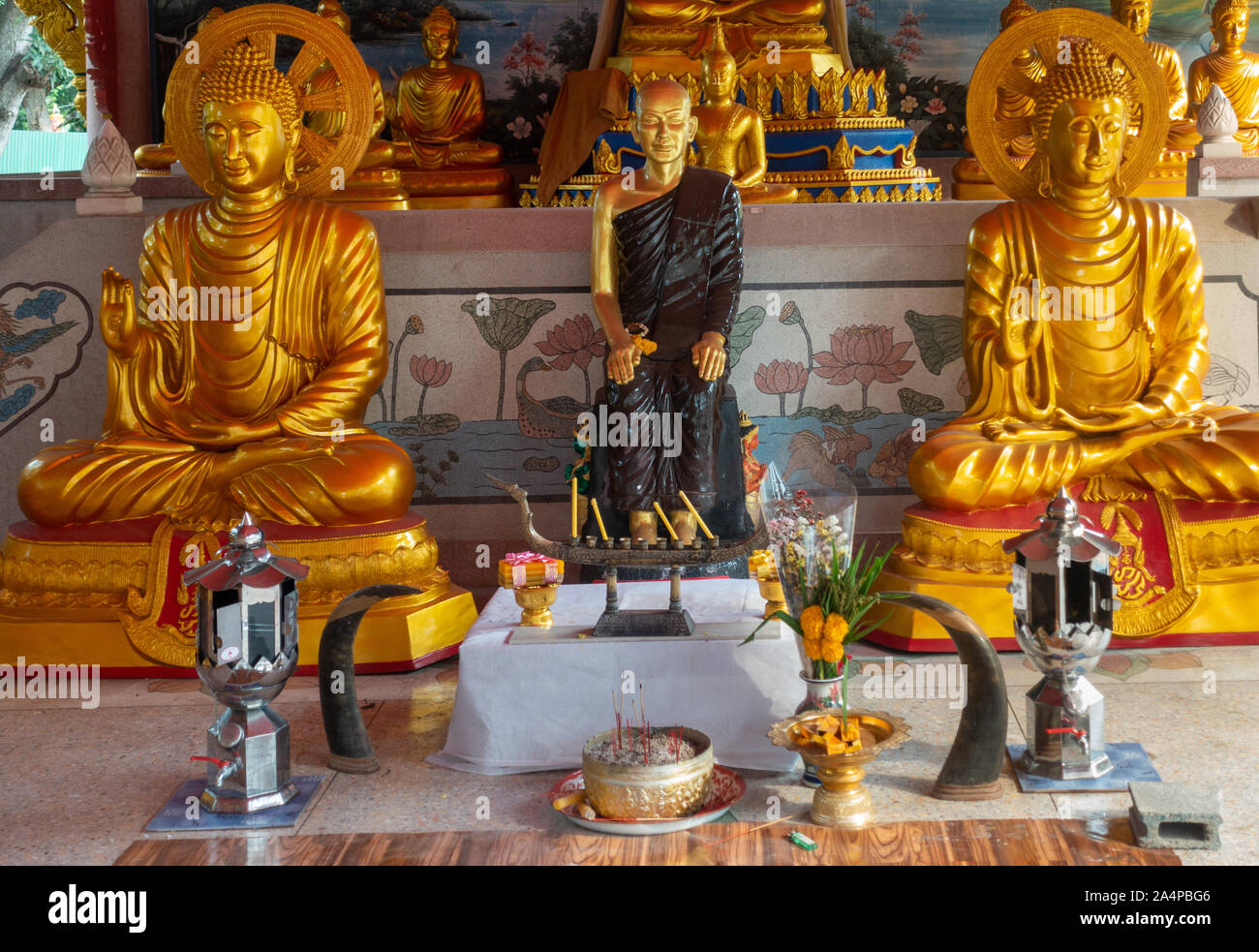 Bang Saen, Tailandia - 16 Marzo 2019: Wang Saensuk monastero buddista. Primo piano della centrale di statue dorate, fondatore affiancato da 2 golden Buddha in m Foto Stock